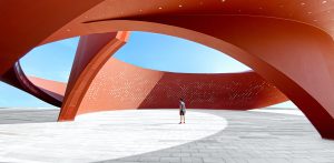 A person standing in a red curved abstract architectural space, 3D rendering