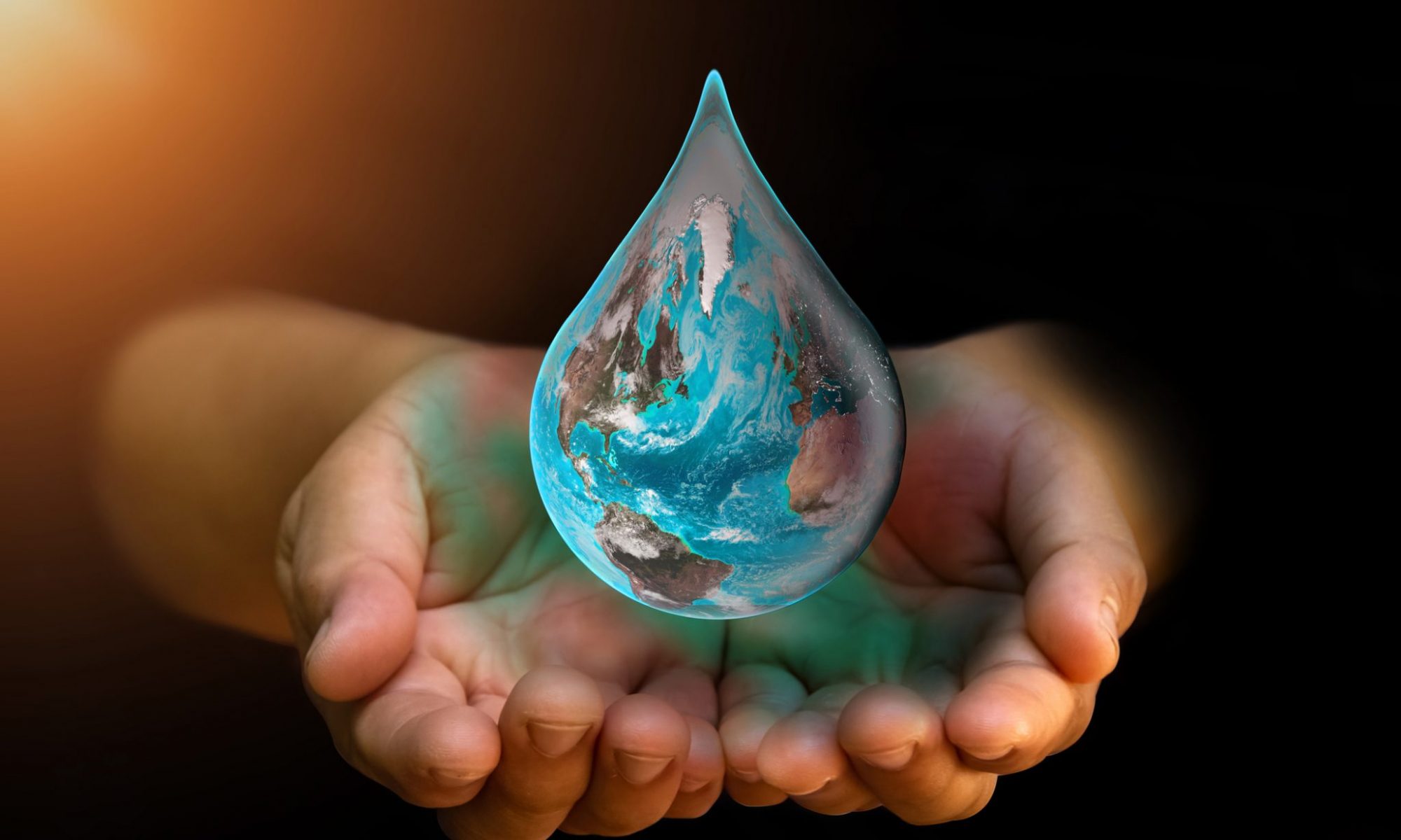 Hands cupping the earth that is shaped like a giant water droplet.